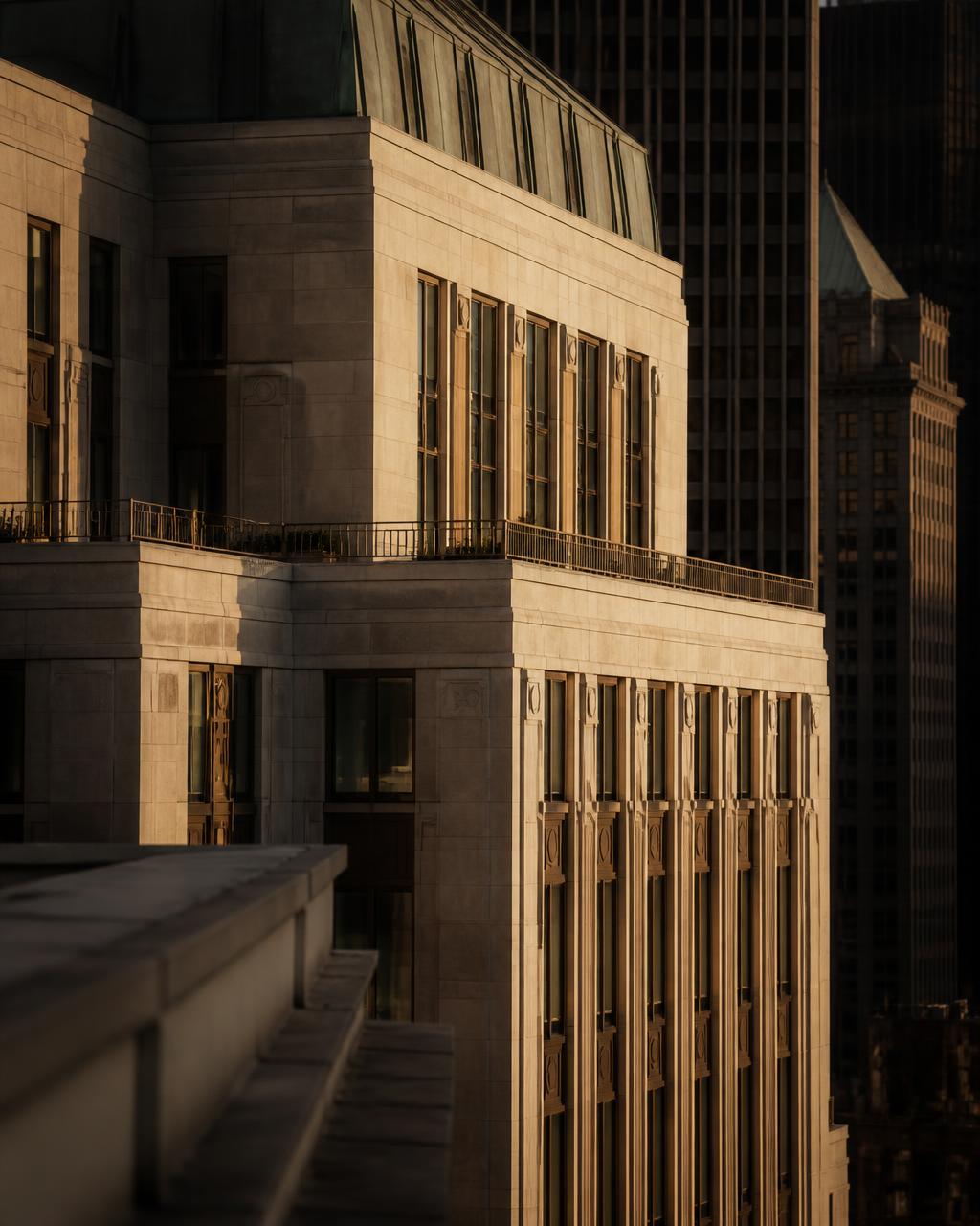 Warm limestone and bronze financial-district tower in late-afternoon light